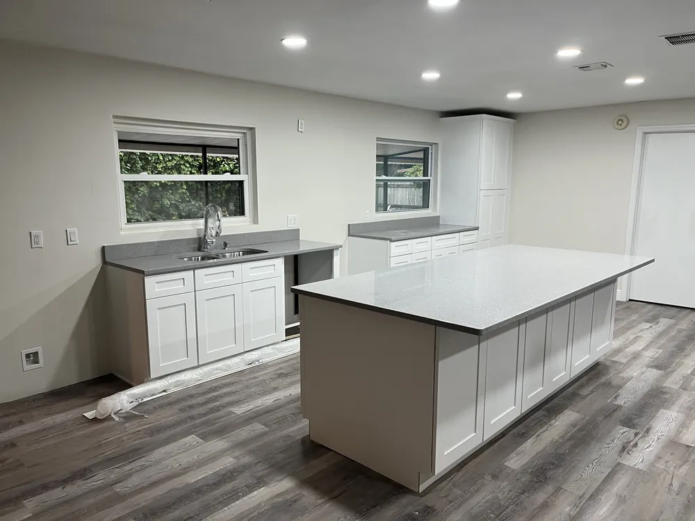 White kitchen with a large center island and quartz countertops