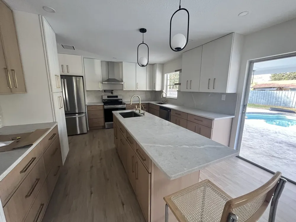 Wood-grain kitchen with a stone island overlooking the pool
